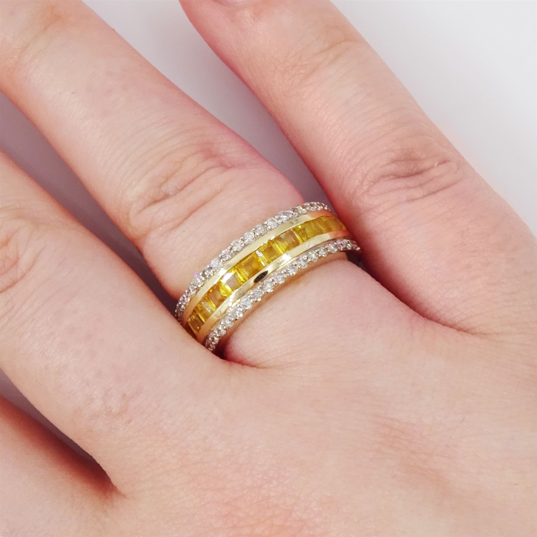 Gold yellow sapphire and diamond three row full eternity ring, channel set calibre cut sapphires, with a row of round brilliant cut diamonds set either side, stamped 9K, total sapphire weight approx 2.95 carat, total diamond weight 0.85 carat