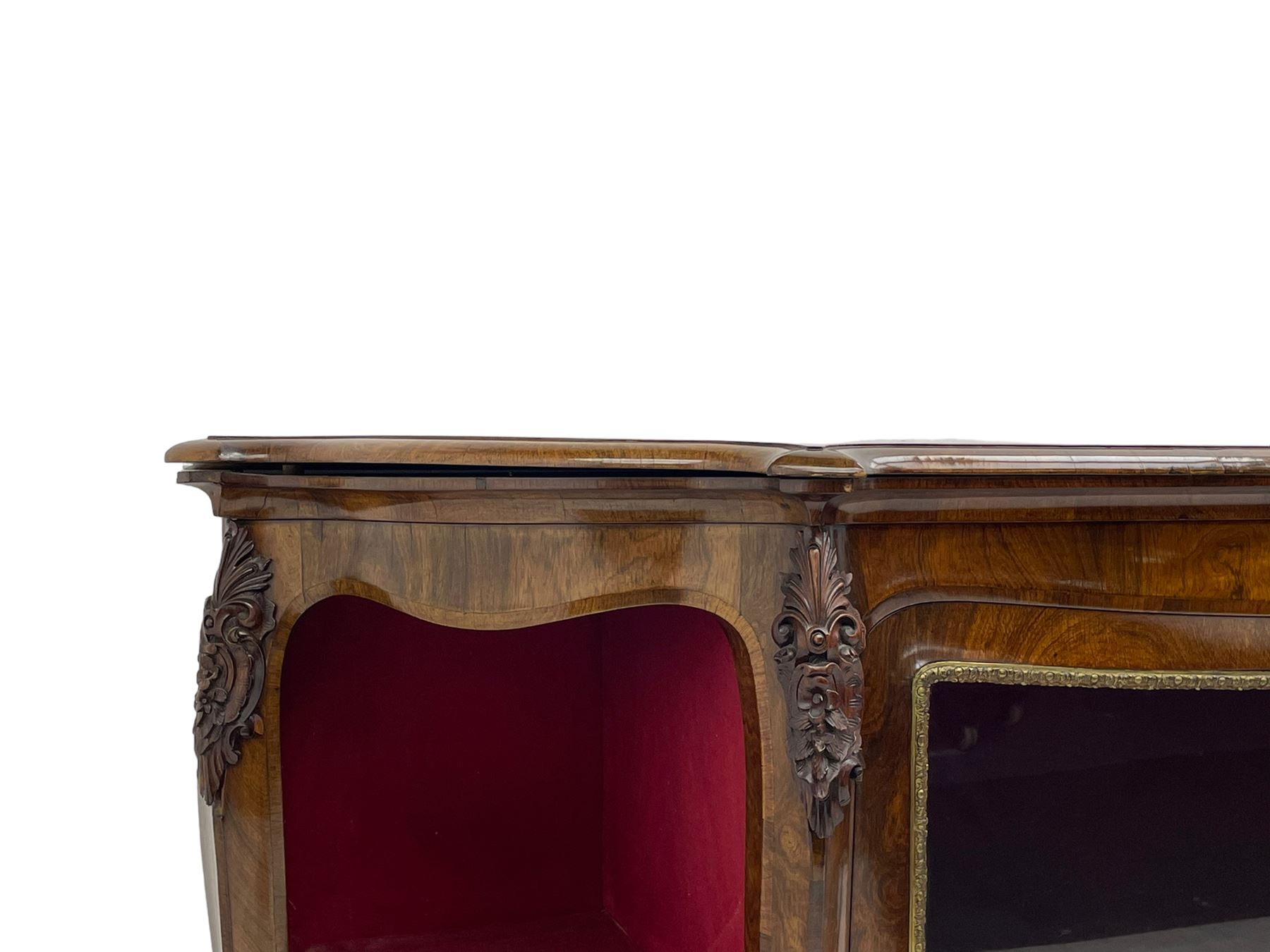 19th century rosewood buffet credenza, bombe form with shaped and moulded top, two central glazed doors with foliate moulded gilt slips, the red fabric-lined interior fitted with a single shelf, flanked by open shelves with raised gilt metal lips, the uprights decorated with shell and flower head carved cartouche mounts, acanthus leaf scroll carved lower mounts, on shaped and moulded plinth base 
