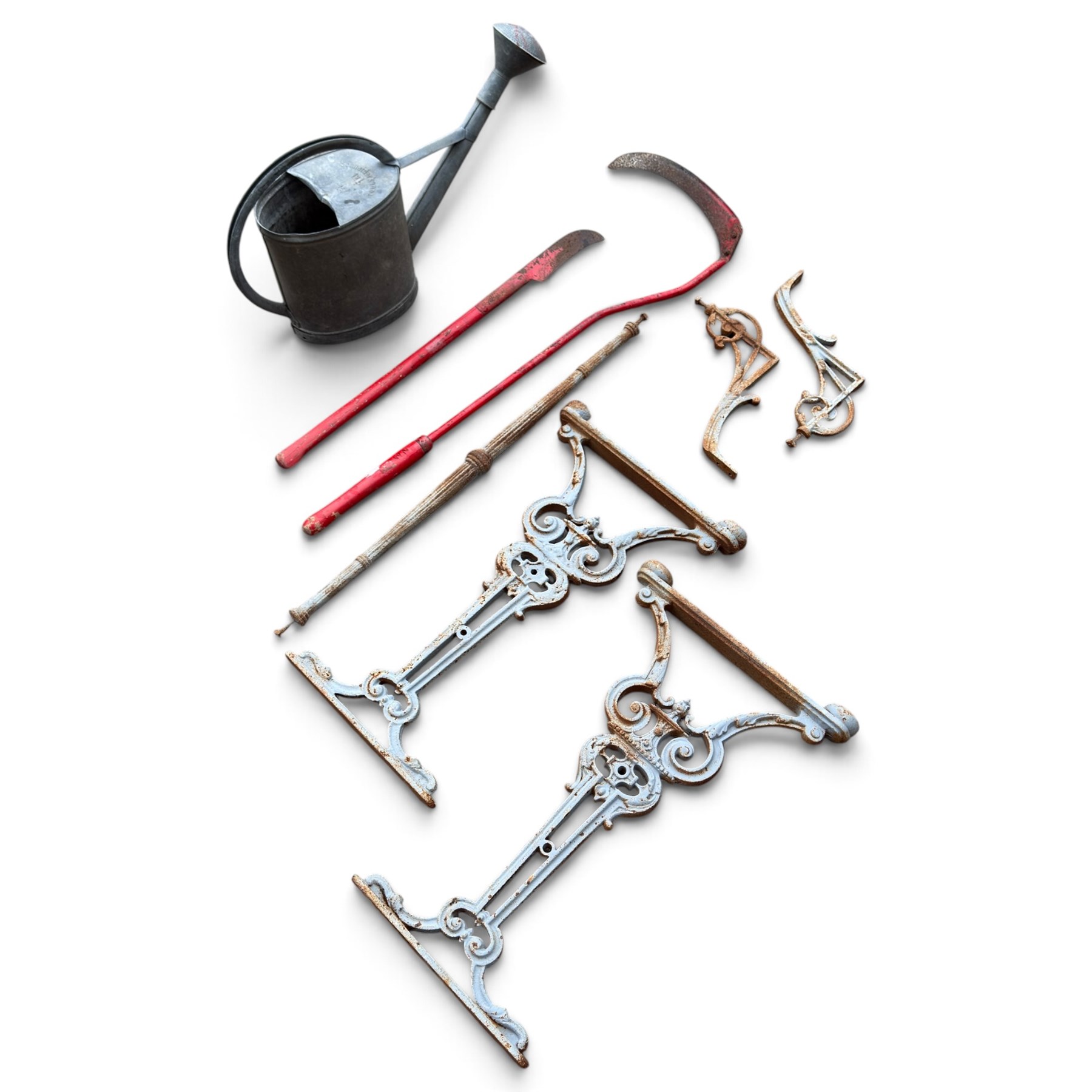 Assorted garden and architectural salvage, comprising a galvanised watering can, two long-handled cutting tools, metal pole, pair of ornate cast iron supports and further decorative fragments