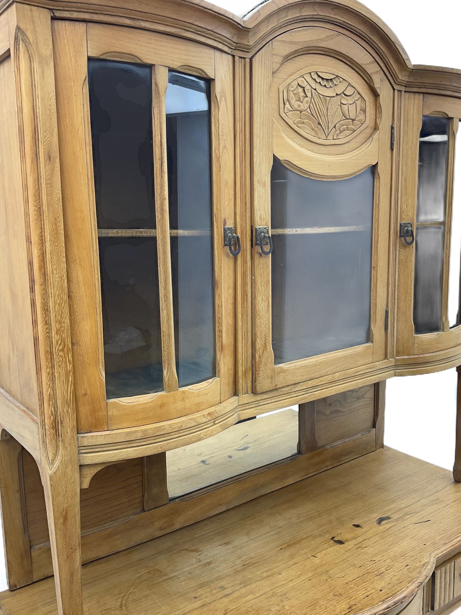 19th century elm dresser, the raised arched top enclosed by three glazed doors, the central door
