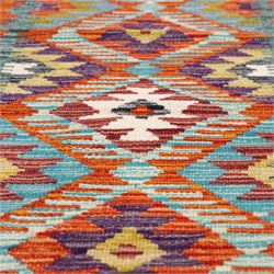 Afghan kilim amber ground runner rug, decorated a central column of repeating lozenge designs in multicolours with concentric geometric motifs, enclosed by an amber guard band with repeating diamond design