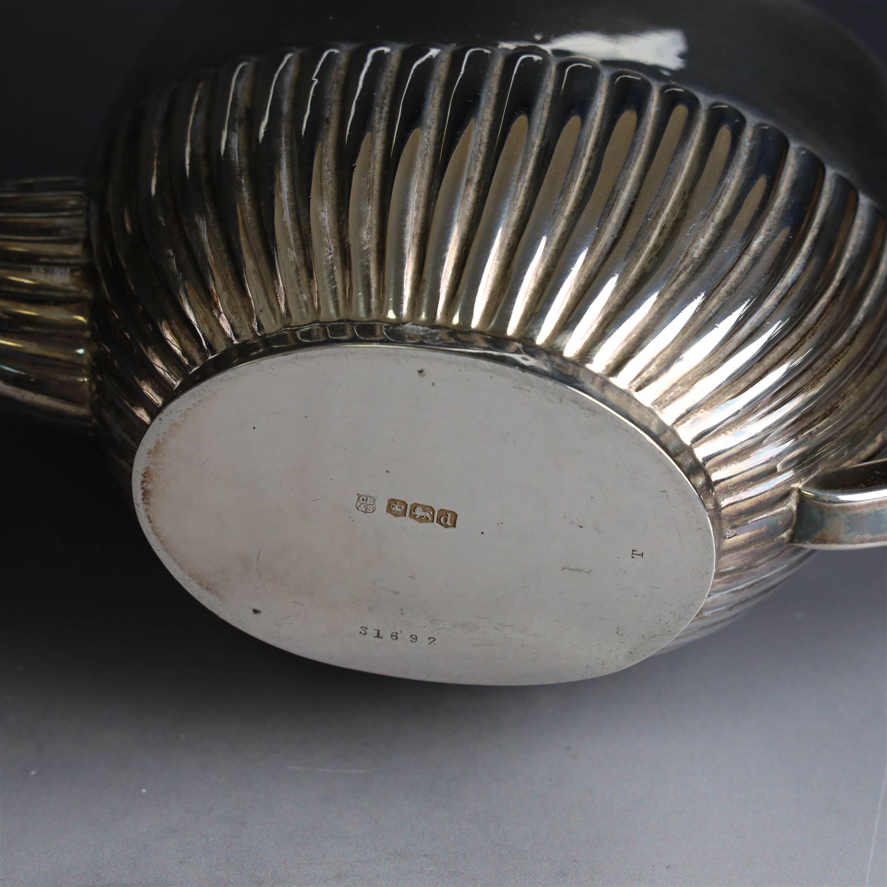 1920s silver three piece tea service, comprising teapot, twin handled open sucrier and milk jug, each of oval part fluted form, the teapot with Bakelite type handle and finial, hallmarked Cooper Brothers & Sons Ltd, Sheffield 1922