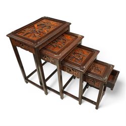 Carved hardwood nest of four occasional tables, each with rectangular top carved with figural scenes, on square supports with hoof terminals united by stretchers 