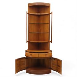 Nathan for Parker Knoll - corner cabinet, the upper section enclosed by two curved glazed doors with glass shelves, over a shaped base fitted with a single frieze drawer and panelled twin cupboard doors