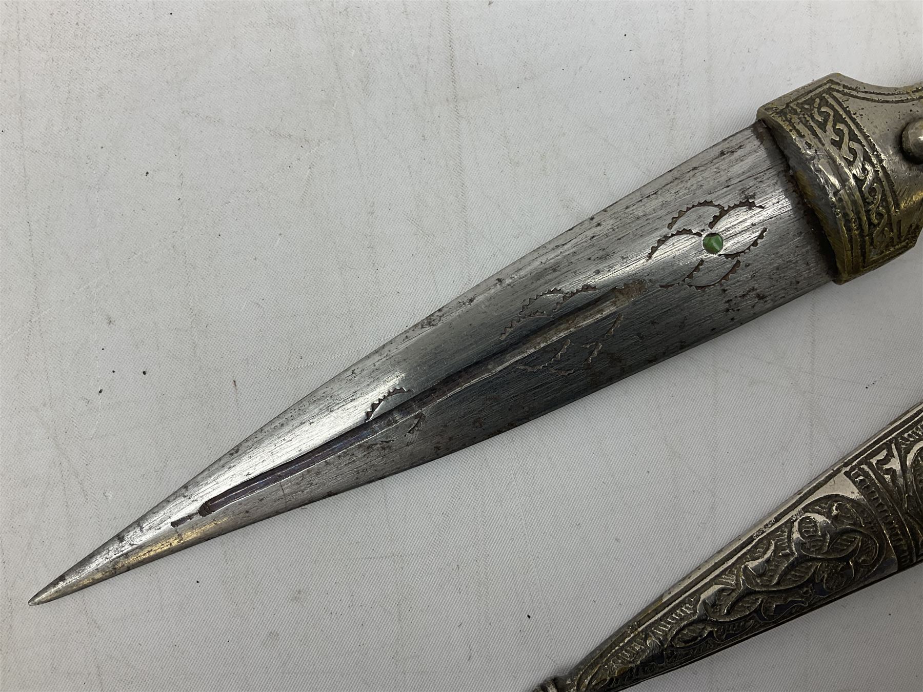 Caucasian qama or kindjal dagger, the 15cm pointed double edged blade with centre fuller and two-piece horn grip;  in nickel plated scabbard with panels of figures and script L28.5cm overall; and eastern knife with 20.5cm curving blade and decorative horn grip; in leather covered scabbard (2)