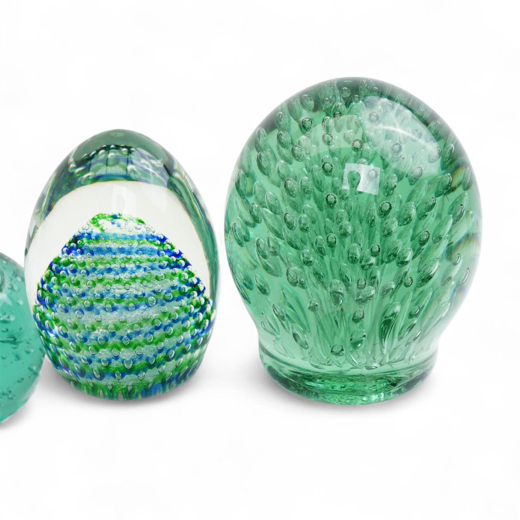 Eleven Victorian and later green glass dump paperweights, with floral and bubble inclusions, largest H14cm 