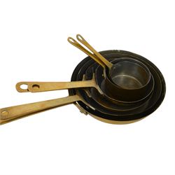 Copper and brass measures, including set of three copper jugs, set of four graduating brass pans and two sets of copper and brass cup measures