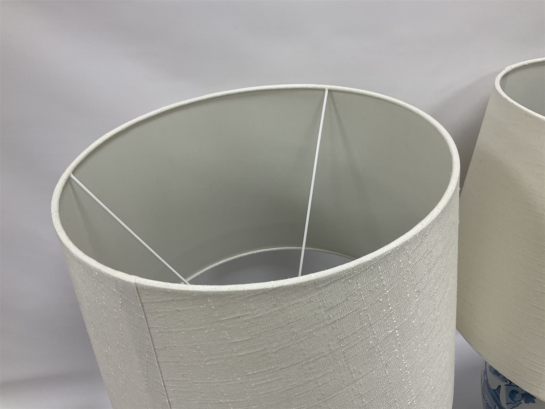 Pair of Chinese table lamps of baluster form, each decorated with landscape scene, raised upon gilt circular base, including shade H63cm