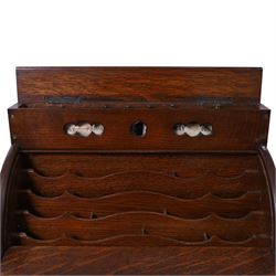 Victorian oak perpetual calendar roll-top desk, tambour front enclosing fitted interior with pigeonholes and pen trays, the raised back fitted with rotating date and month apertures, over single frieze drawer with cast brass handle, on plinth base