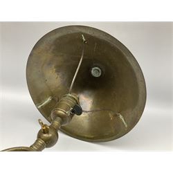 Arts & Crafts Jesson, Birkett & Co, brass table lamp or wall light, designed by Thomas Birkett, the tapering stem with adjustable ball pivot supporting a conical shade with tapering final with ball terminal, upon a circular domed base pierced for wall mounting, shade positioned upright overall H57cm

Often misattributed to Arthur Stansfield Dixon for Birmingham Guild of Handicraft, this particular lamp was designed by Thomas Birkett.
In the late 1890's Birkett worked as a metalwork at the Birmingham Guild, before later joining the Faulkner Bronze Company which went on to become Jesson, Birkett & Co in 1904. The lamp features in lighting catalogues from the firm under the model no E490.

