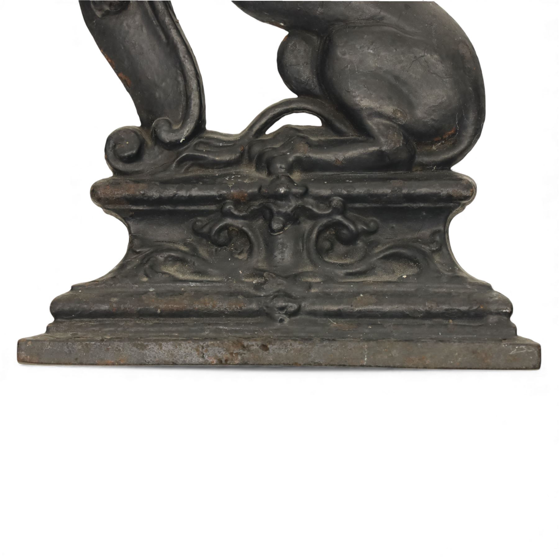 Victorian cast iron figural doorstop in the form of a lion, depicted seated with curled tail and detailed mane, raised foreleg resting against a scroll motif, set on an integral stepped base with moulded edges and foliate ornament