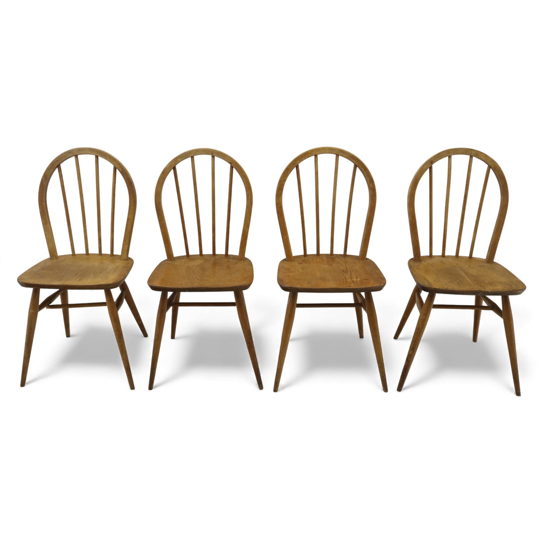 Ercol - Windsor dining chairs, set of four, each with rounded hoop back and four stick spindles, shaped elm seats with exposed plugs, raised on splayed beech tapering legs