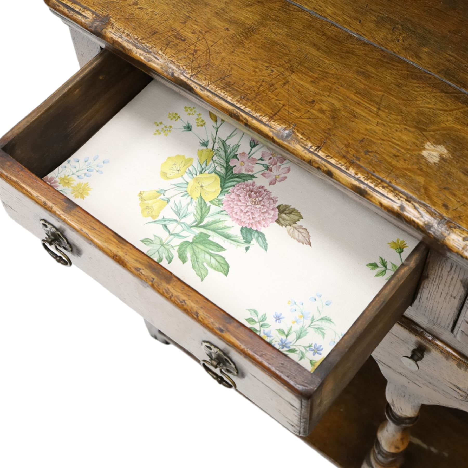 Georgian design oak dresser of small proportions, moulded cornice over open plate rack with two shelves and shaped apron, the base fitted with two drawers over three small drawers, brass drop handles, shaped apron, on square supports united by pot board
