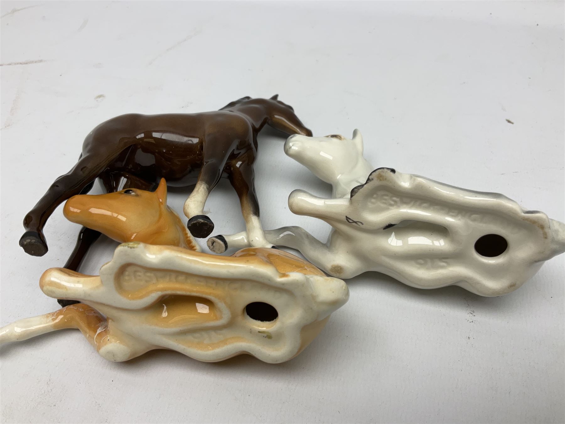 Three Beswick figures of horses, comprising Palomino foal 915, Dapple Grey foal and bay, together with Bing & Grondahl 1852 fledging sparrow modelled as a hungry baby bird and two other animal figures