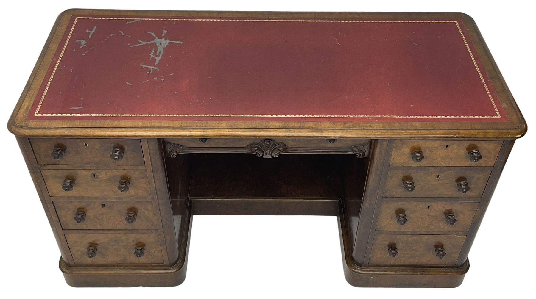 Victorian figured walnut kneehole desk, moulded rectangular top with inset leather writing surface, fitted with nine drawers, the central frieze drawer with carved curled foliage mount, on moulded plinth base,