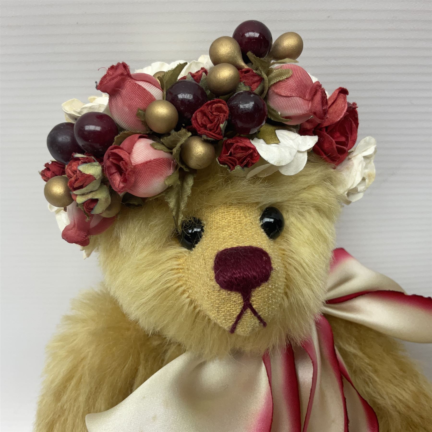 The Cotswold Bear Company - two teddy bears from ‘The Flower Collection’ comprising ‘Mayflower’ no.99/100, blonde mohair with dark pink flower crown and bow, H33cm; ‘Phoenix’ no. 99/100, blonde mohair with white and red rose flower crown and bow, H28cm; both with original labels and purchase receipt (2)