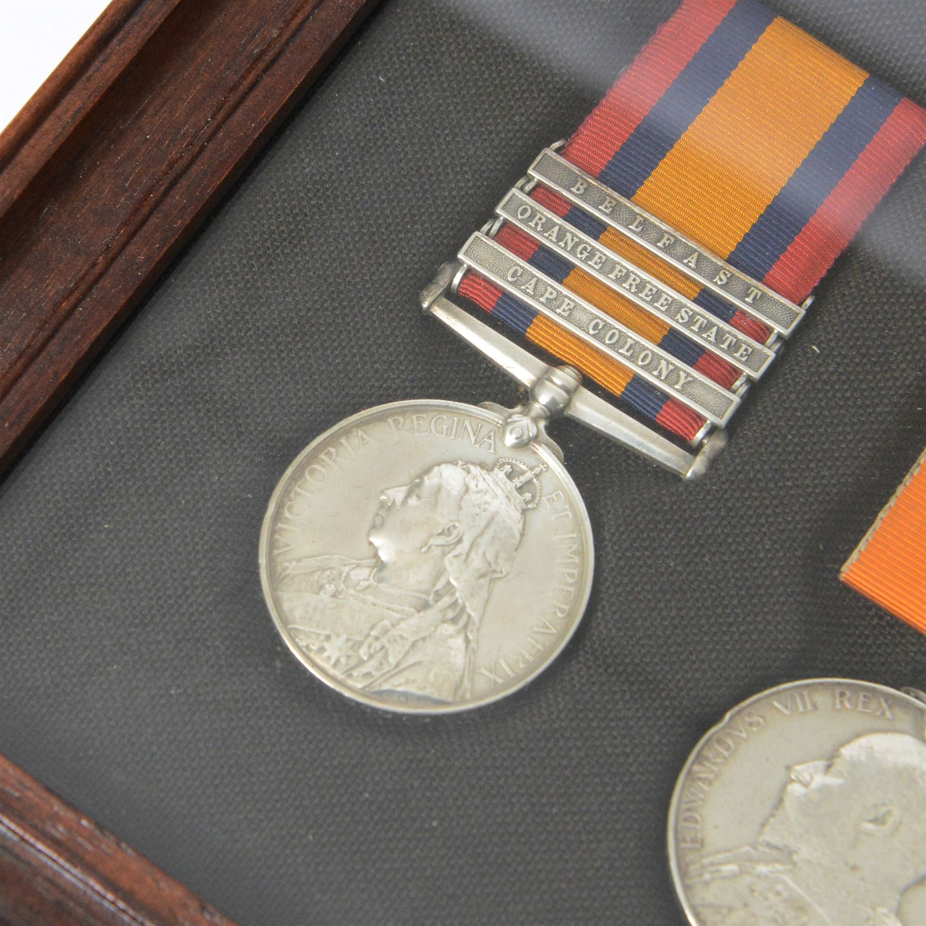 Victorian Queens South Africa Medal with Belfast Orange Free State and Cape Colony clasps, Kings South Africa medal, awarded to 72 Pte W Wilson Scots Gds and WWI war medal and 1914 star, awarded to 9335 Pte W Neilson S Gds, all framed with Scots Guard Beret badge to the centre 