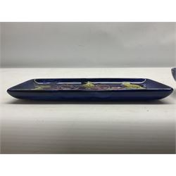 Moorcroft rectangular pin dish decorated in the Clematis pattern upon cobalt blue ground, together with a small circular footed dish decorated in the Hibiscus pattern, both with impressed marks beneath, tray L20cm (2)