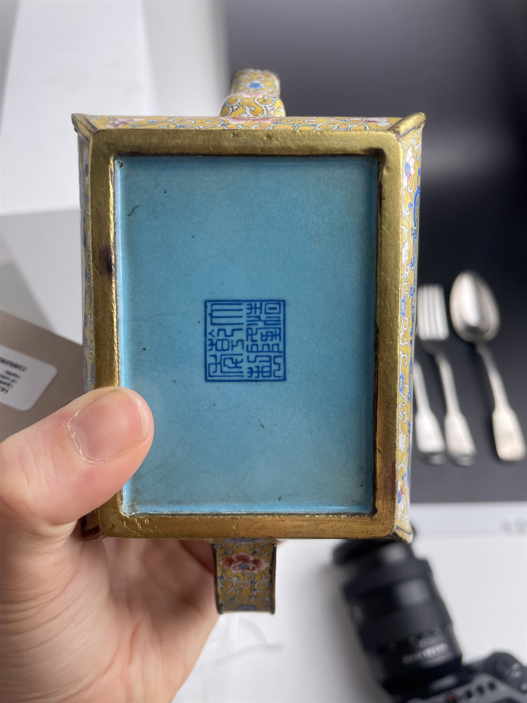 Chinese Qianlong enamel bombé shaped teapot, decorated with scenes of scholars examining a scroll and drinking on a yellow ground with various traditional floral and foliate motifs, the painted scene framed within trailing blue vine border, with Qianlong marks to base L15cm