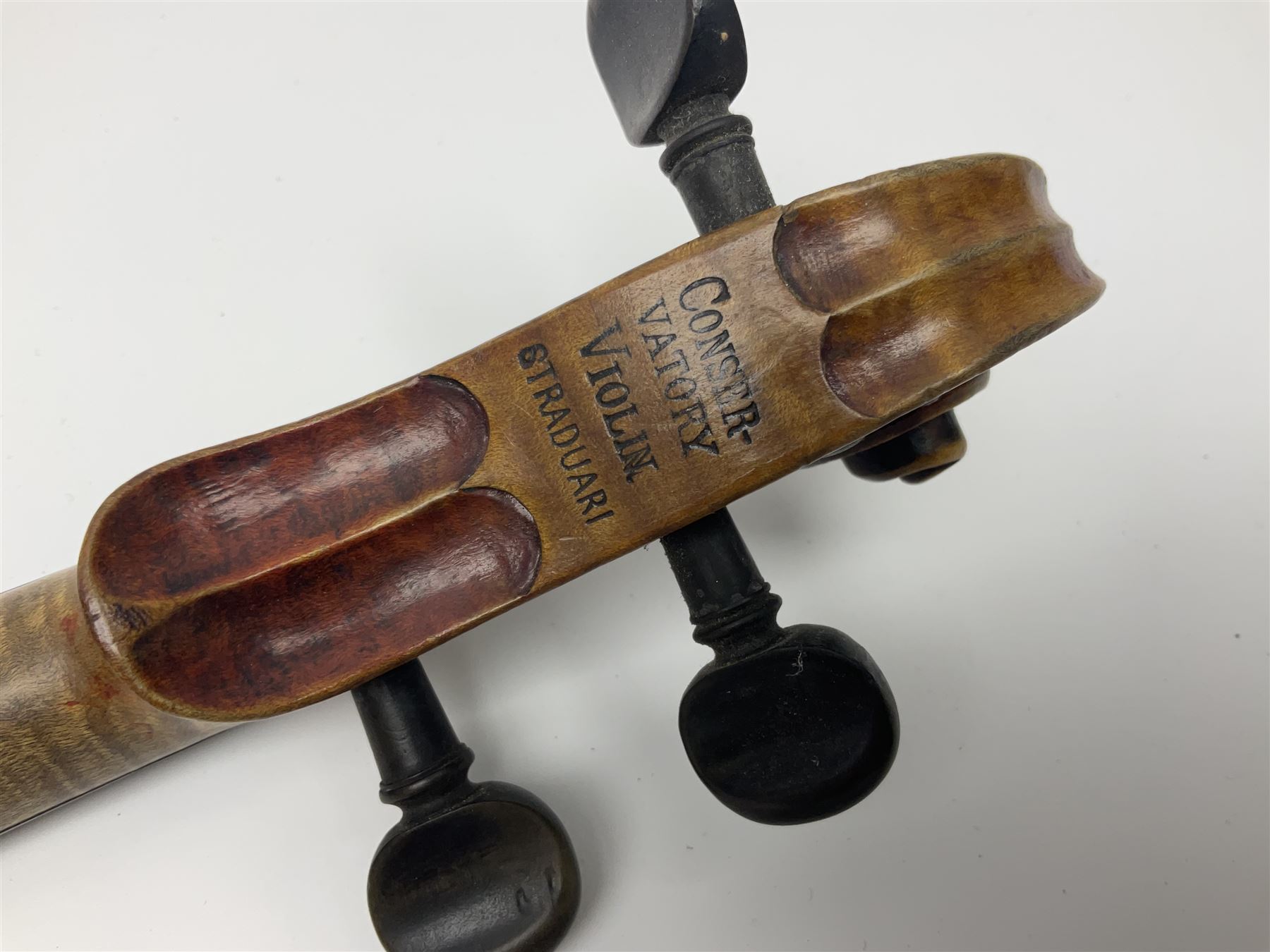 Late 19th century French three-quarter size 'Conservatory' violin with 34cm two-piece maple back and ribs and spruce top, the peg box inscribed 'Conservatory Violin Straduari', bears label 'Antonius Stradiuarius Cremonensis Faciebat Anno 1721' L55.5cm overall; in ebonised wooden 'coffin' case; and Saxony violin c1900 with 36cm two-piece maple back and ribs and spruce top; bears label 'Antonius Stradivarius Cremonensis Faciebat Anno 17**' L59cm overall; in carrying case (2)