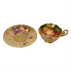 Royal Worcester fruit painted cabinet teacup and saucer, interior hand painted with apples, blackberry and cherries upon a mossy ground, the cup exterior and centre of saucer gilded, cup and saucer signed Rickells, each with puce coloured printed marks beneath, H7cm