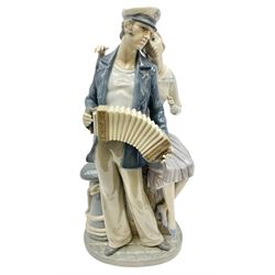 Lladro figure, Sailors Serenade, modelled as a sailor playing an accordion with a woman seated upon a crate, no 5276, year issued 1985, year retired 1988, H32cm