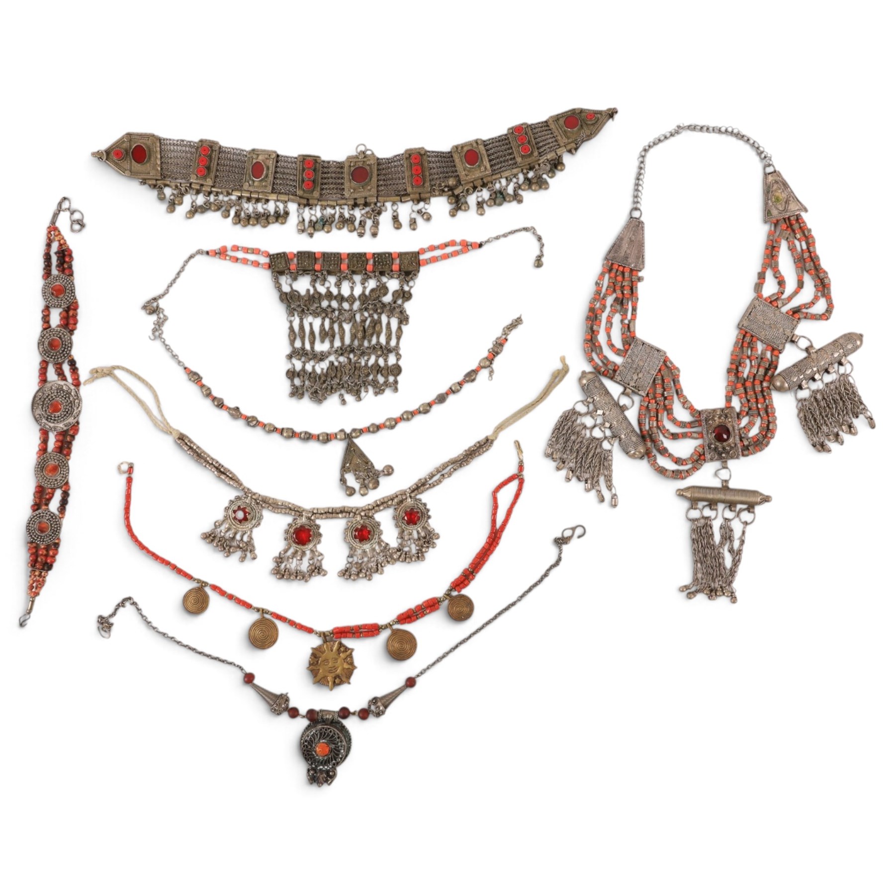 Collection of Middle Eastern jewellery, including silvered multi strand necklace with beadwork and filigree decoration with three cylindrical pendants, pendant necklace with central orange cabochon, beadwork choker and similar  