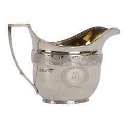 George III silver three piece tea service, comprising teapot with ivory scroll capped curved handle and ivory finial to the hinged cover, twin handled open sucrier with gilt interior, and cream jug with gilt interior, each of oval form with rounded sides, the bodies engraved with central monogram within a seaweed wreath, between engraved foliate bands, hallmarked John Emes, London 1801, teapot including handle H17cm

This item has been registered for sale under Section 10 of the APHA Ivory Act