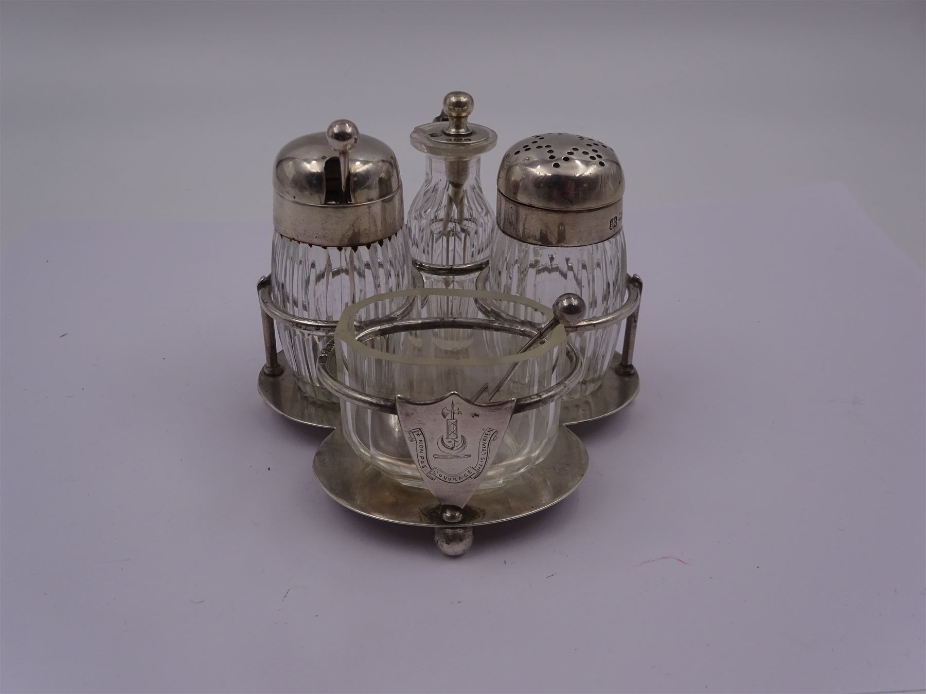 Late Victorian silver mounted four piece cut glass cruet set on stand, comprising pepper shaker, open salt, mustard pot and vinegar bottle, the silver stand with shield engraved with the Workman family crest, hallmarked Hukin & Heath, London 1899, including bottles H7cm