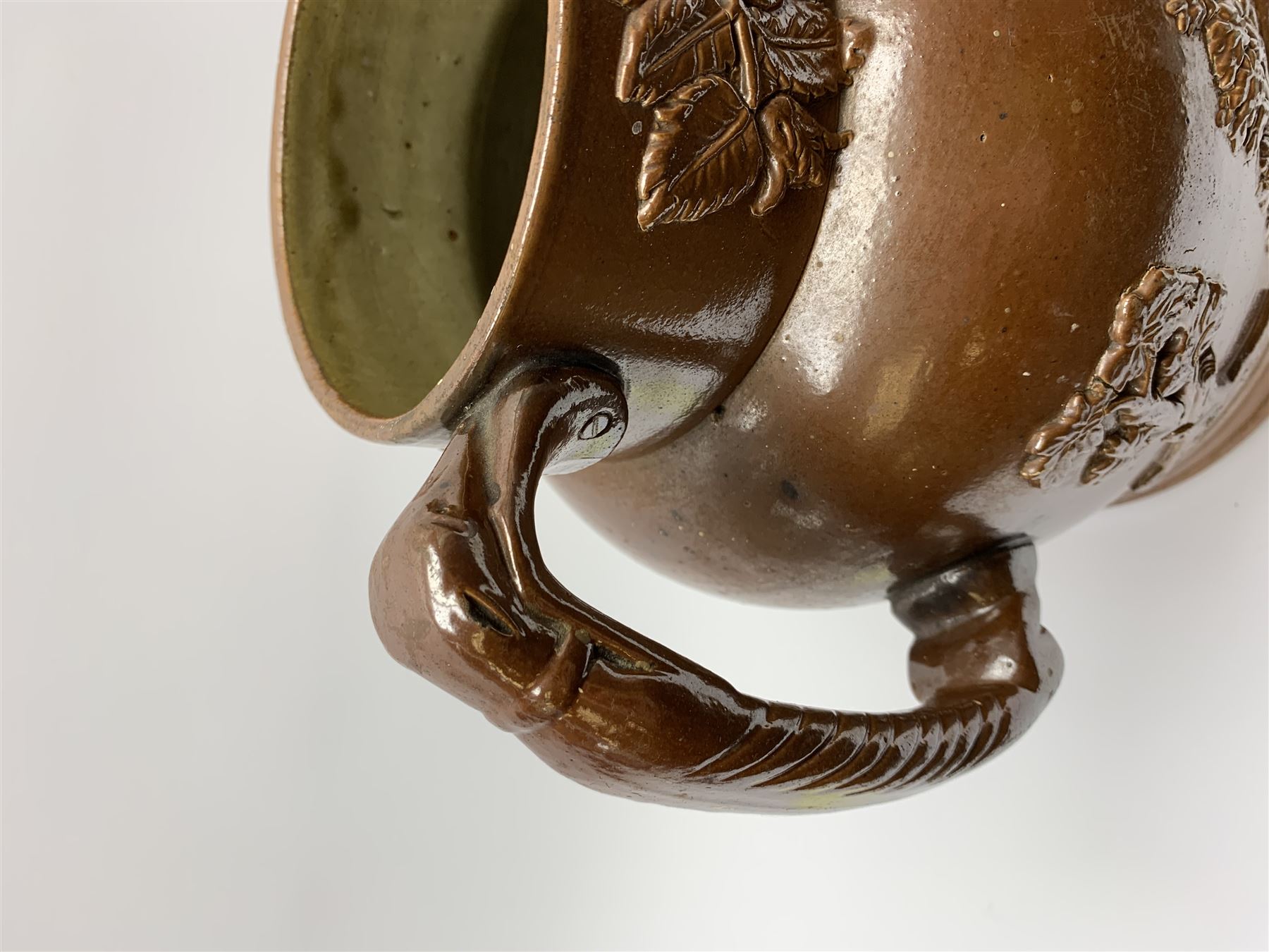 19th century salt glazed stoneware jug, with mask spout and greyhound modelled handle, the body decorated in relief with Royal Coat of Arms flanked by lions, the rim with the flowers of the union, roses, thistles and shamrocks, H26.5cm
