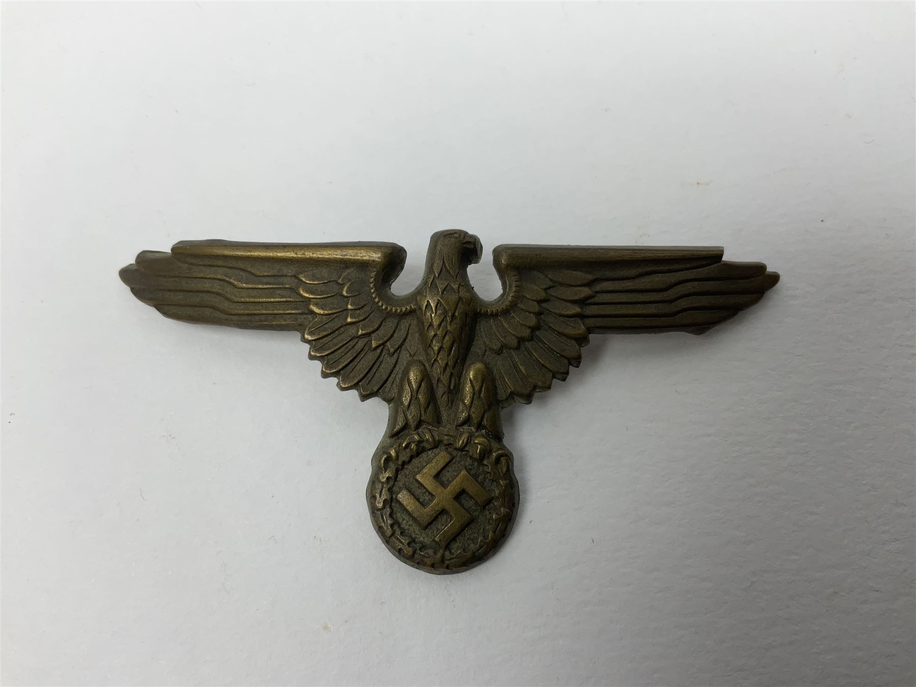 Five German 'SS' visor cap metal badges comprising one eagle and four skull and cross-bones (5)