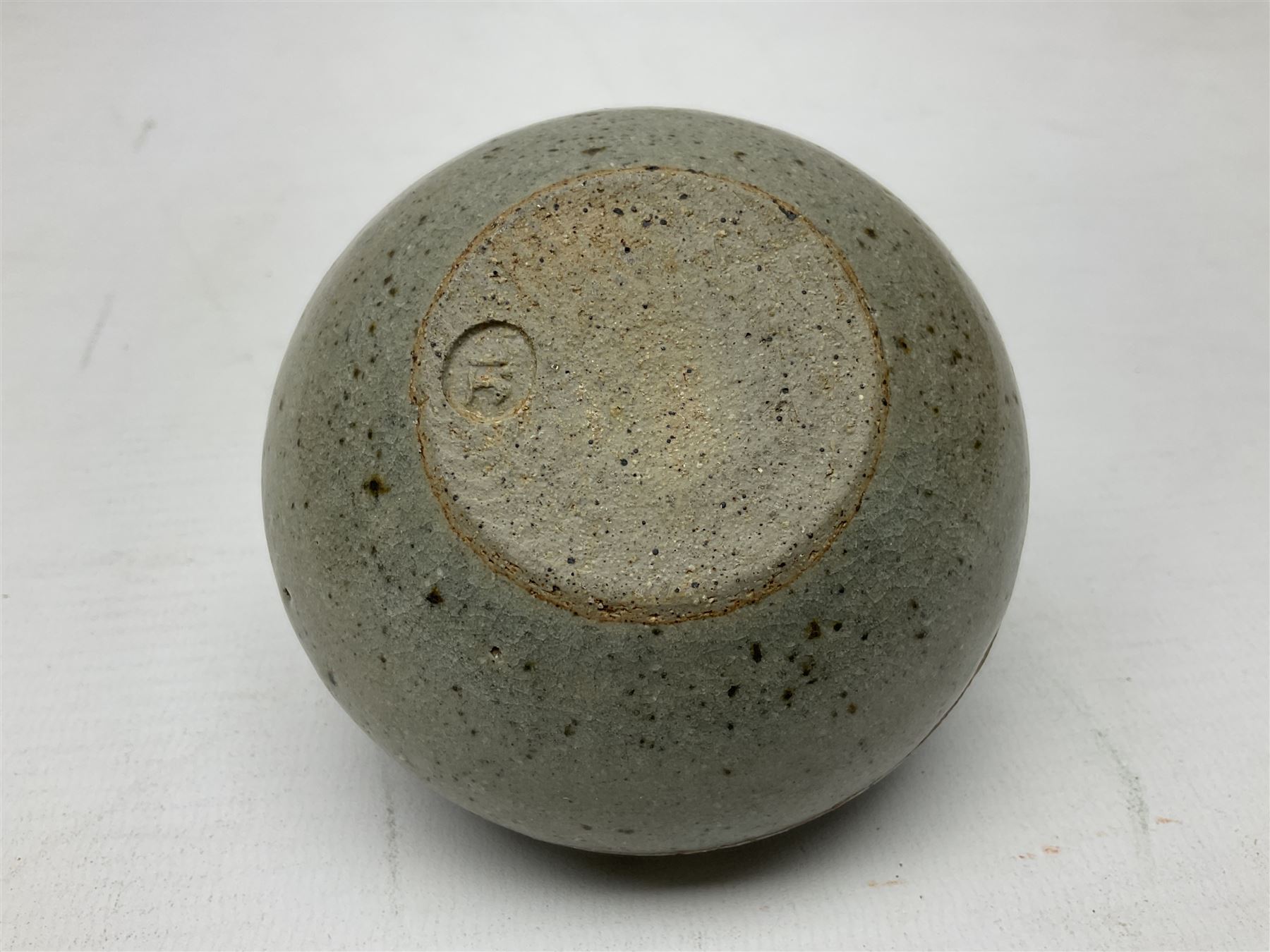 Janet Leach (American, 1918-1997) for Leach Pottery; speckled studio pottery vase of shouldered ovoid form with speckled brown decoration and trailing green and brown glaze upon beige and brown ground, with impressed J.L. monogram and Leach Pottery mark beneath, together with a Jeremy Leach blue speckled lidded circular dish with loop handle, impressed J.L, tallest H11cm