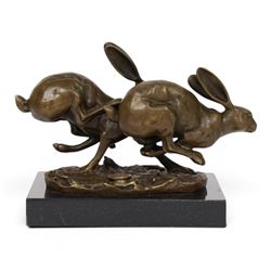 Bronze figure group, modelled two hares in chase, upon naturalistically modelled oval base signed Nick and with foundry mark, raised upon black marble base, H11cm L12.5cm