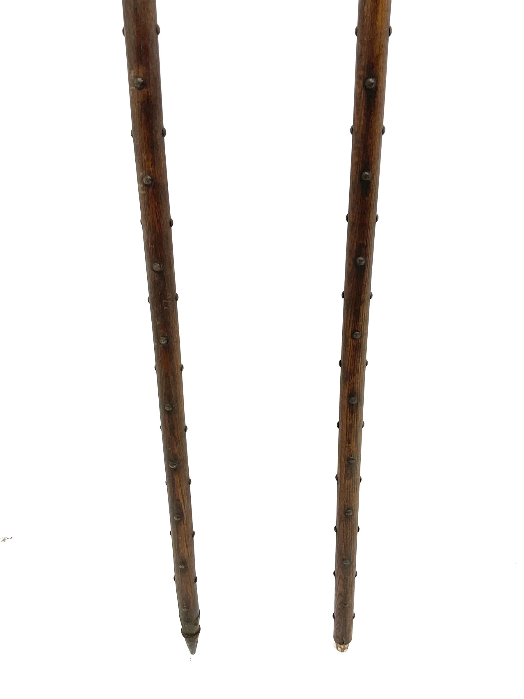 Large continental steel halberd axe the engraved blade with cast sunburst centre and long studded ash handle L219cm; and another halberd with plain ribbed blade and studded ash handle with ground spike (2)