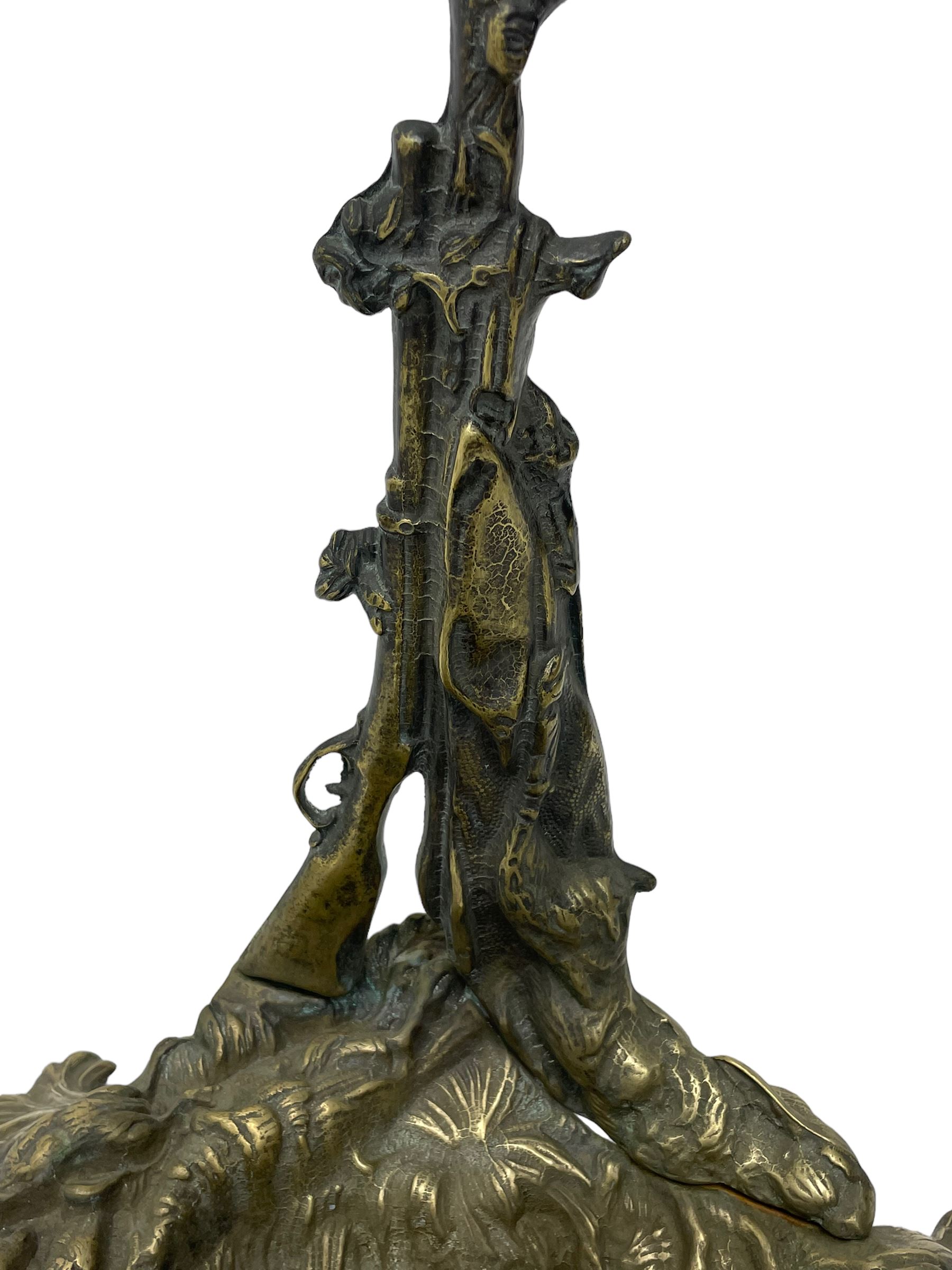 Pair of cast brass hallway umbrella or stick stands, in the form of a tree decorated with trailing flowering foliage branches, the stem with hunting horn over leaning shotgun, shaped naturalist tray base with hunting hound and out splayed foliate cast feet 