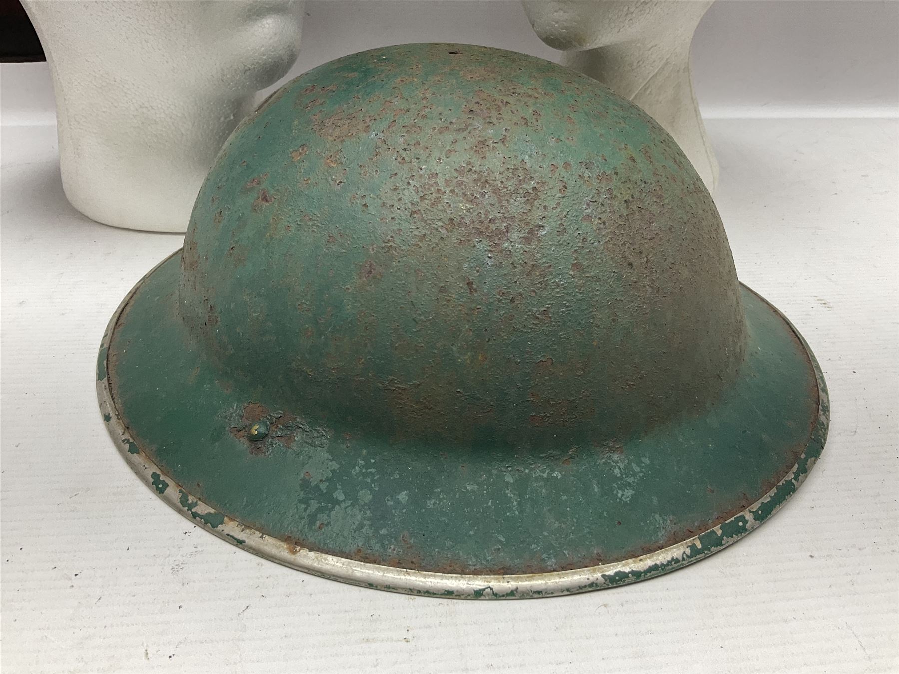 Three battlefield relic helmet shells - WWI German M16; WWI French Adrian; and WWII British (3)