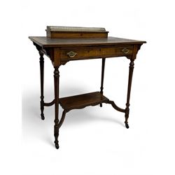 Late Victorian walnut writing table, rectangular leather-inset top surmounted by a brass gallery, fitted with a single frieze drawer, raised on turned tapering supports with lower undertier and ceramic castors