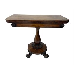 Victorian mahogany tea table, rectangular top with rounded corners, folding and swivelling to reveal interior surface, supported on a faceted baluster-shaped column, raised on a circular platform base with carved acanthus details, ending in four lion paw feet