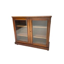 Victorian bookcase, rectangular top over two glazed doors enclosing two shelves, on skirted base