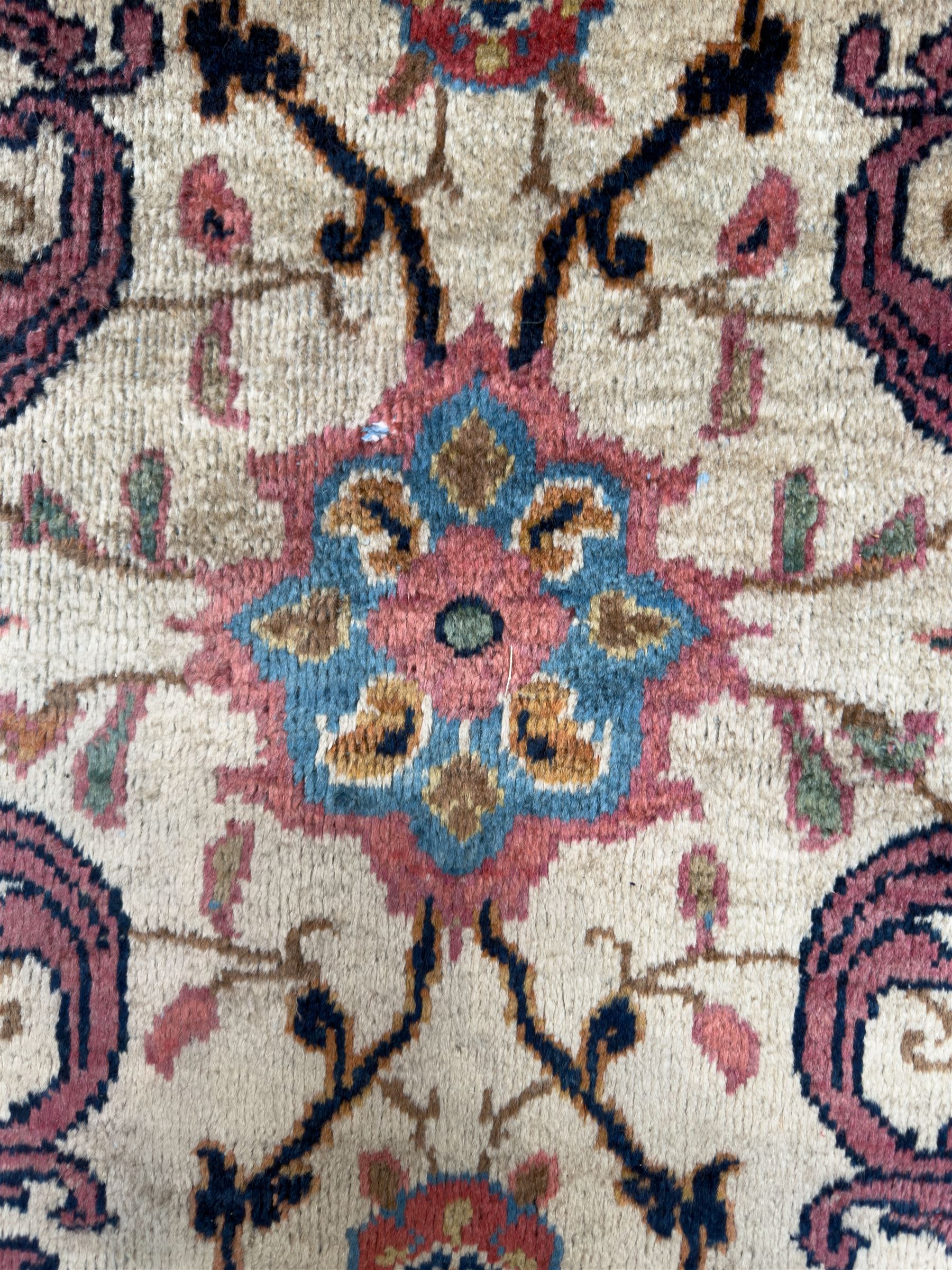 Northwestern Persian Meshkin hand-knotted carpet, the ivory field with an all-over design of scrolling vines and stylised floral sprays in burgundy, pink, and blue tones, enclosed by a raspberry red border of rosettes and palmettes linked by fine arabesques, from the region of Meshkin near Ardabil