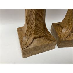 Mouseman - pair of tooled oak candlesticks, wrought iron sconce with drip tray over tapered octagonal column carved with mouse signature, terminating to stylised leaf carved square base, by the workshop of Robert Thompson, Kilburn
