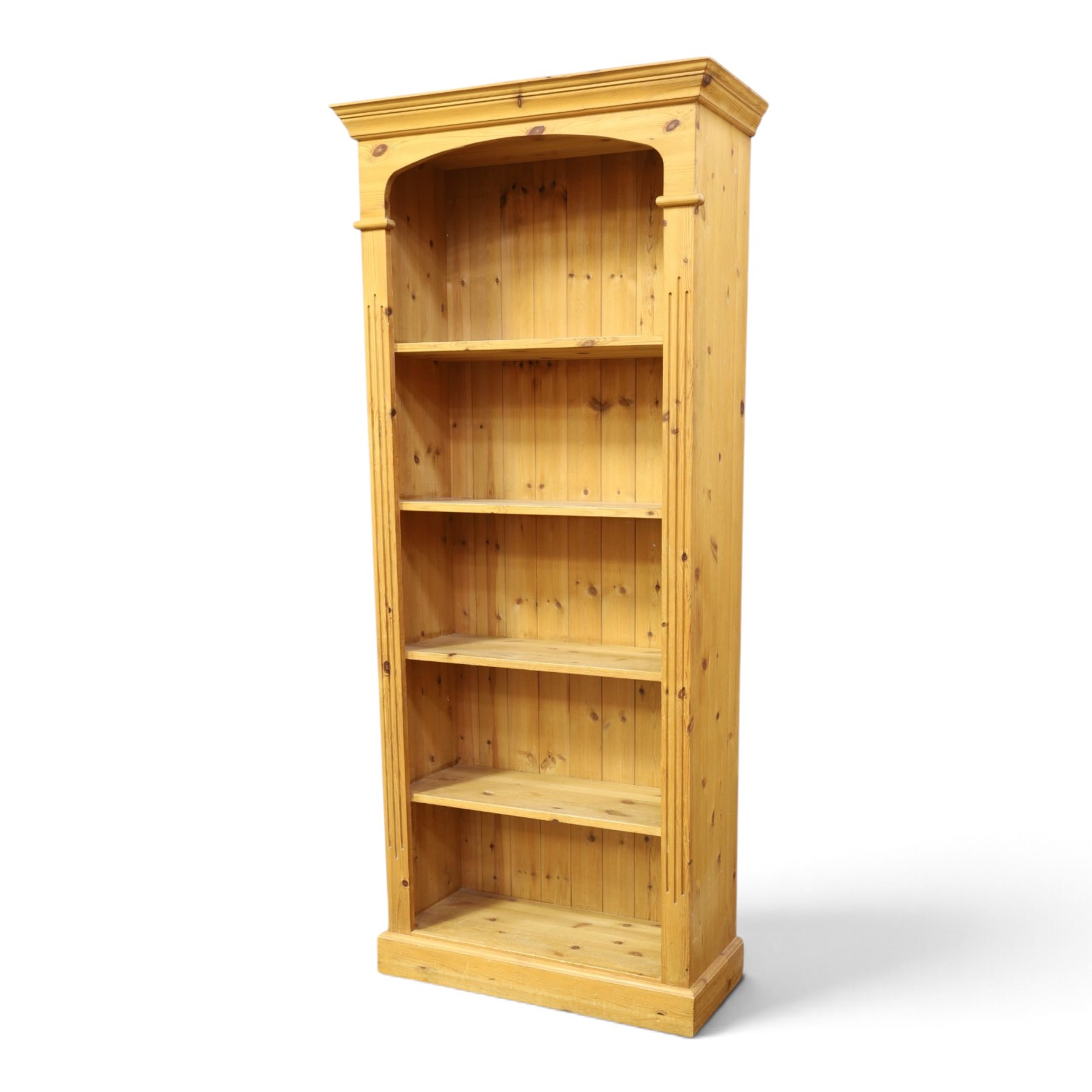 Traditional pine bookcase, projecting cornice with four fixed shelves (H 33cm, D 29cm), fluted sides, raised on a plinth base