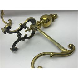 Pair of early 20th century brass fire dogs, each with sphere and urn finial, upon a scrolling base, H38cm