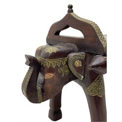Indian hardwood and brass bound bench or coffee table, the rectangular top with embossed brass banding in a repeating flower head pattern, flanked by pierced handles, raised on twin end supports in the form of elephant masks decorated with brass-work, over elephant leg supports