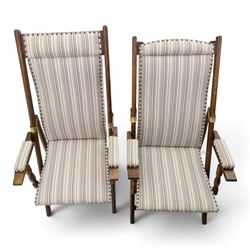 Pair of early 20th century oak framed garden reclining and folding deckchairs, high back and seat upholstered in striped fabric with padded armrests