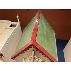Seagull Pub - scratch-built wooden doll's house as a two-storey gable fronted public house painted in white green and maroon; the hinged front with ground floor veranda and window over opening to reveal two fully furnished rooms with dog-leg staircase and well stocked bar with bar-tender L31cm H62cm D37cm; together with Corner Shop and Dollies Pantry; a similarly painted scratch-built wooden two-storey flat-roofed doll's house as a well stocked ground floor grocery shop with stairs up to two further fully furnished rooms and more stairs giving access to a roof terrace L46cm H57cm D33cm (2)