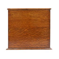 Victorian brass mounted oak tantalus, containing a set of three decanters, fitted with a games compendium to the front, H32cm