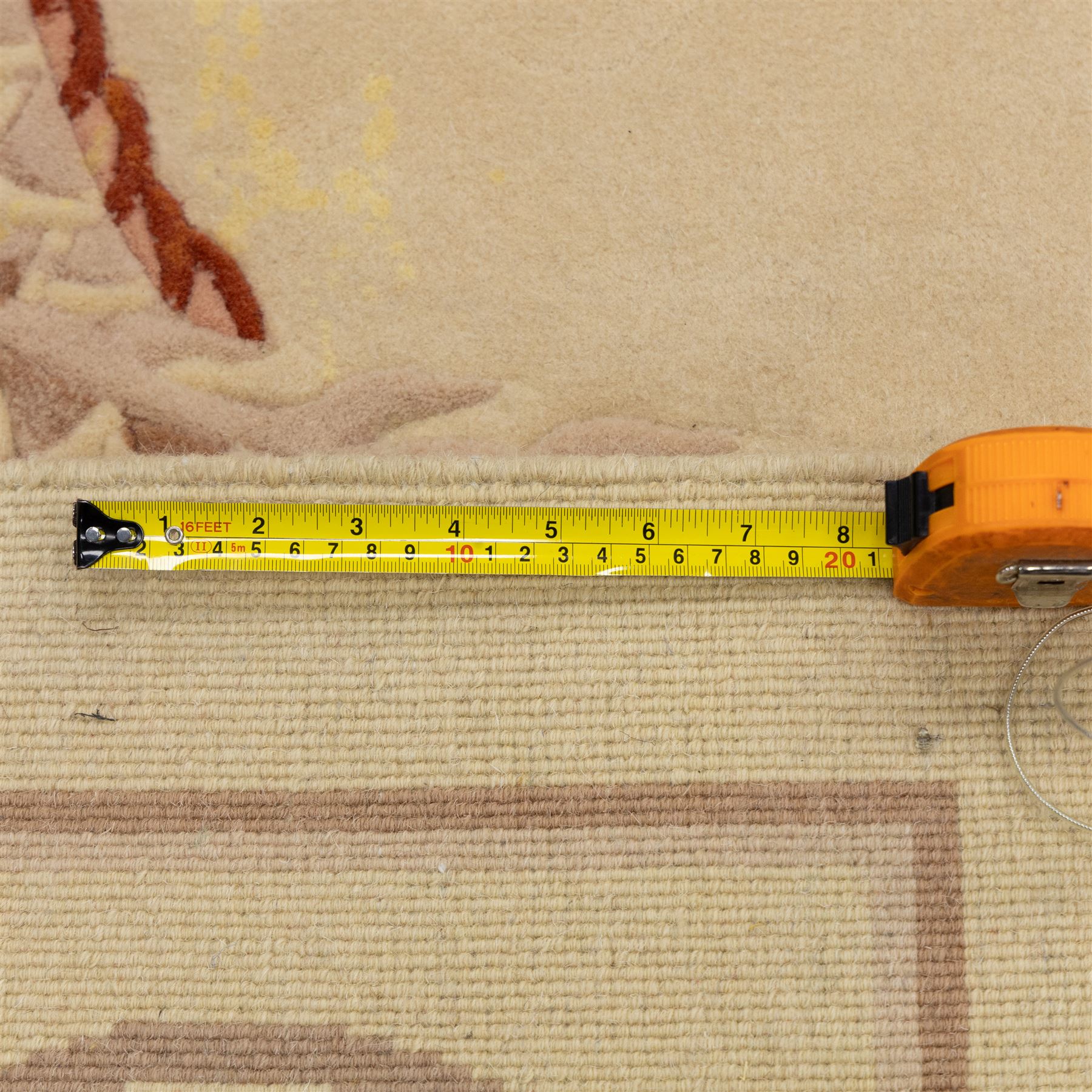 Late 20th century Chinese wool carpet, cream field with five stylized dragons arranged in a circular formation around a central flaming pearl motif, dragons depicted with elongated bodies and clawed feet amongst stylized cloud forms, enclosed within a narrow inner border and a wider outer border decorated with traditional Chinese motifs and symbols