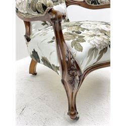Victorian walnut framed open armchair, moulded spoon back carved with flower heads and foliage, upholstered in buttoned white ground and floral pattern 'Symphony' fabric by Sanderson, shaped scrolled arms above cabriole supports carved with flower heads