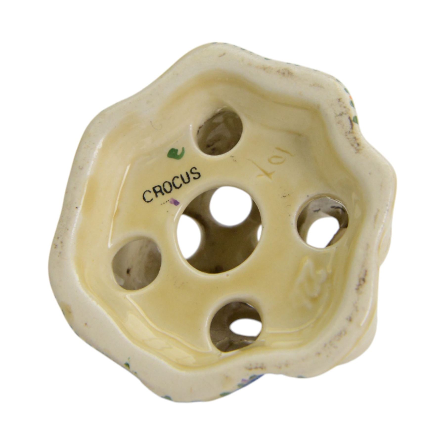 Royal Staffordshire Crocus by Clarice Cliff teacup and saucer, with printed mark beneath, together with a Clarice Cliff Crocus pattern flower frog, with printed mark beneath, cup H6cm